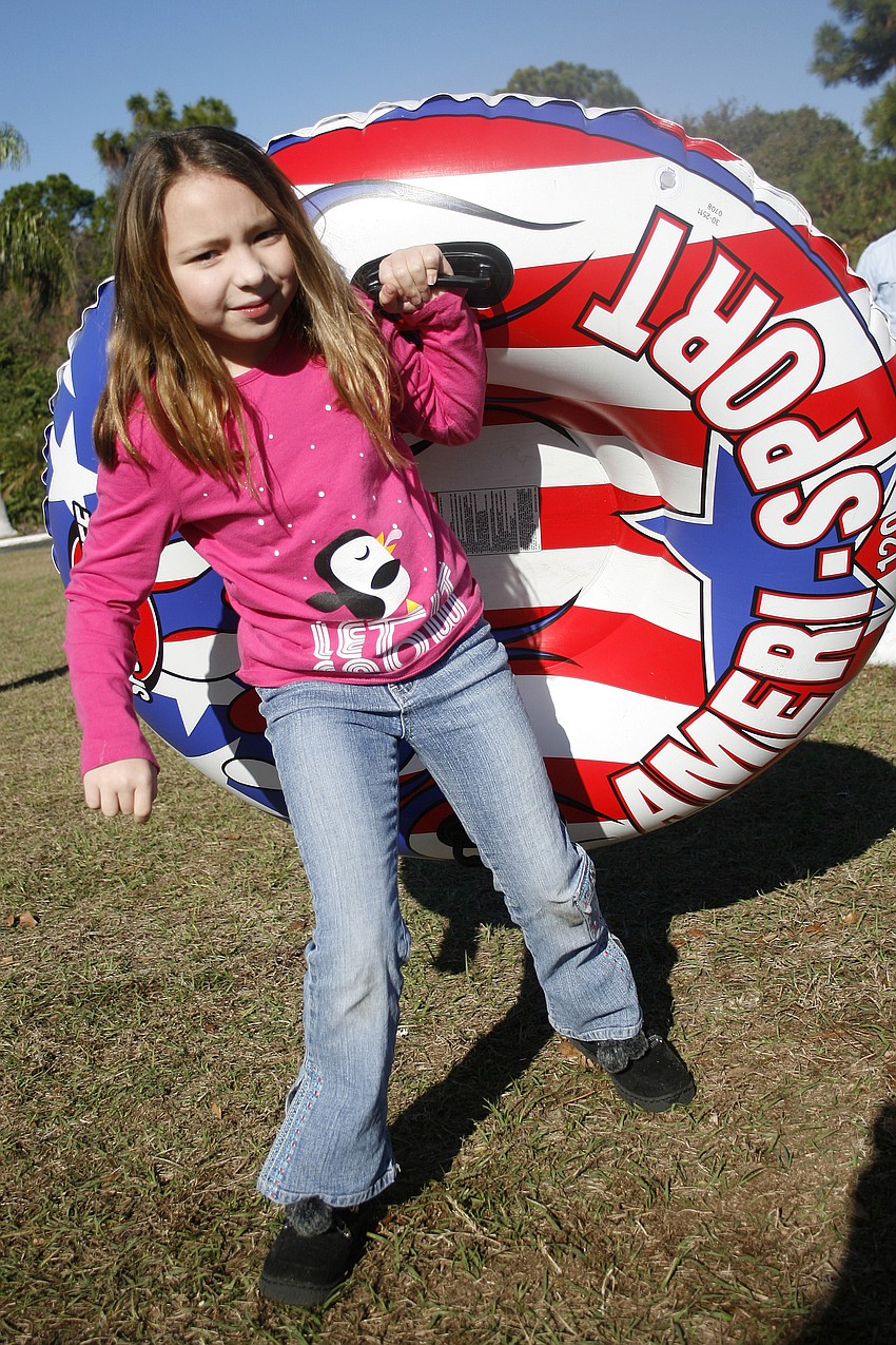 Tori Smith, 8, carried her inflatable raft back up the hill for another trip down the snow.