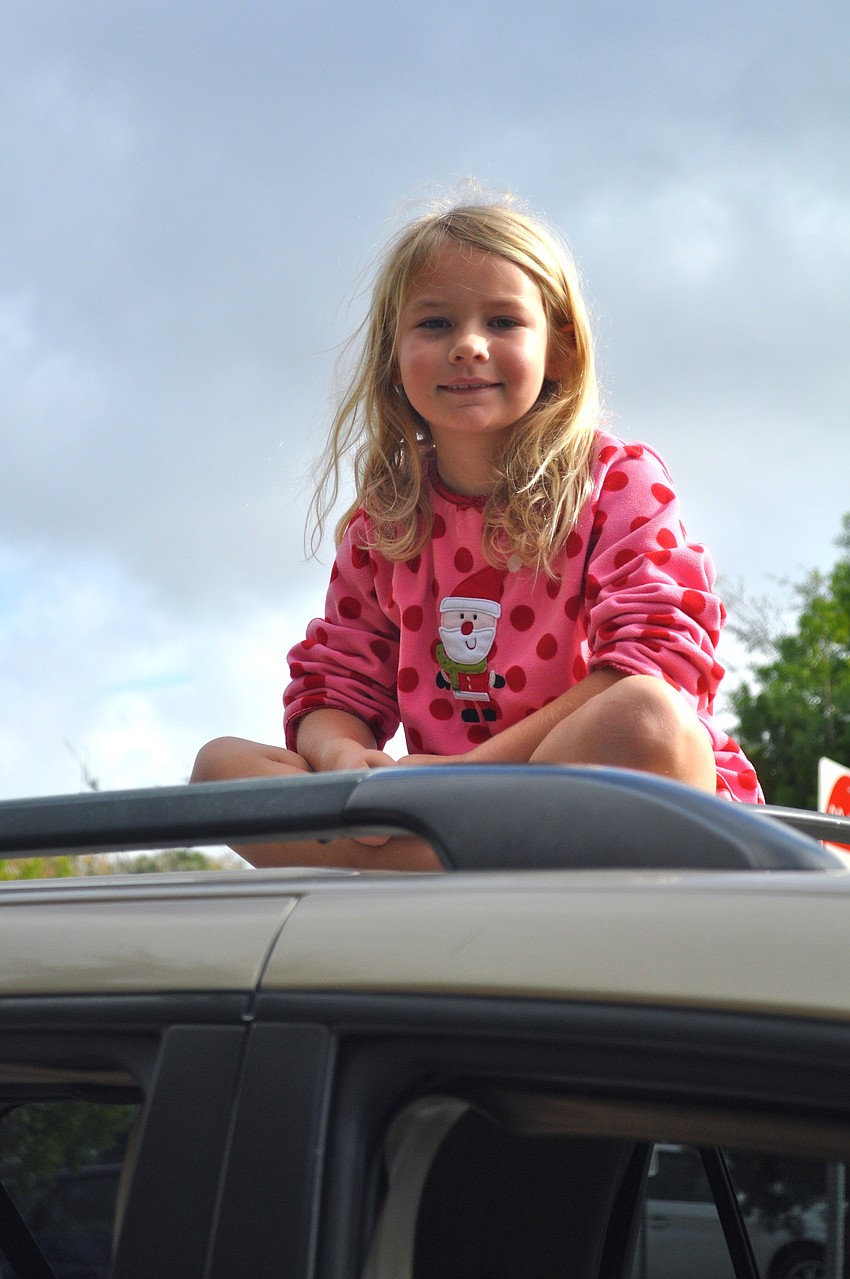 Ruby Johnson cheers on her big brother, Beau, from the top of her family's car.