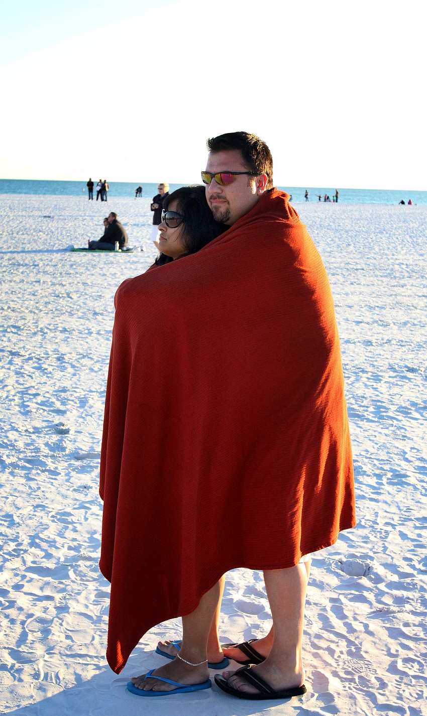 Tom Freeman and Tina Soto, dating for six months, stay warm by snuggling together under a blanket while they watch the Say I Do, Again ceremony, Monday, Feb. 14 on Siesta Key Beach.