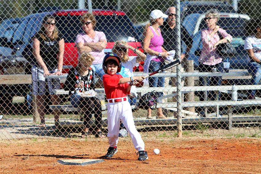 Carson Enos, 7, follows through with his swing after hitting the ball on Saturday, Feb. 19 at Twin Lakes Park during Central Sarasota Little League Opening Day.