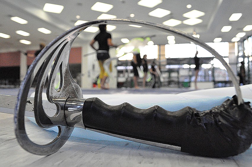 Winter guard members perform with swords during the first part of the show.