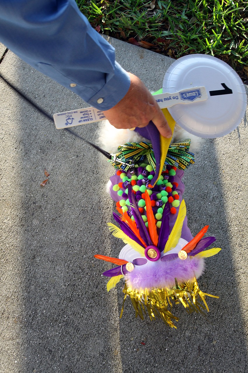Frank Coon fixes Boo's jester hat on Tuesday, Mar. 8 during Masquerade â€” Mardi Gras St. Armands Style.