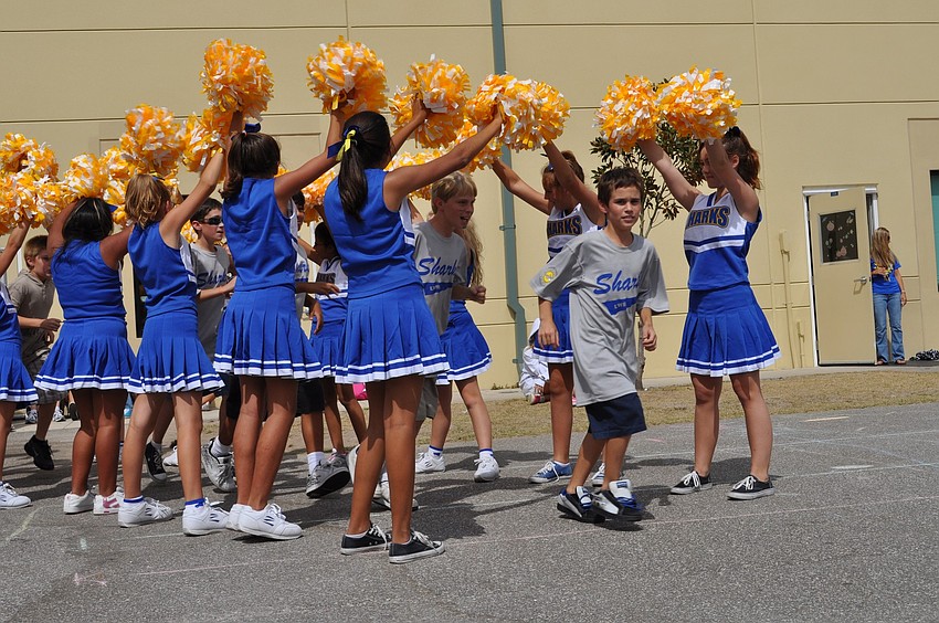 Mill Creek resident Mark Gutowski led the football team out for the pep rally.