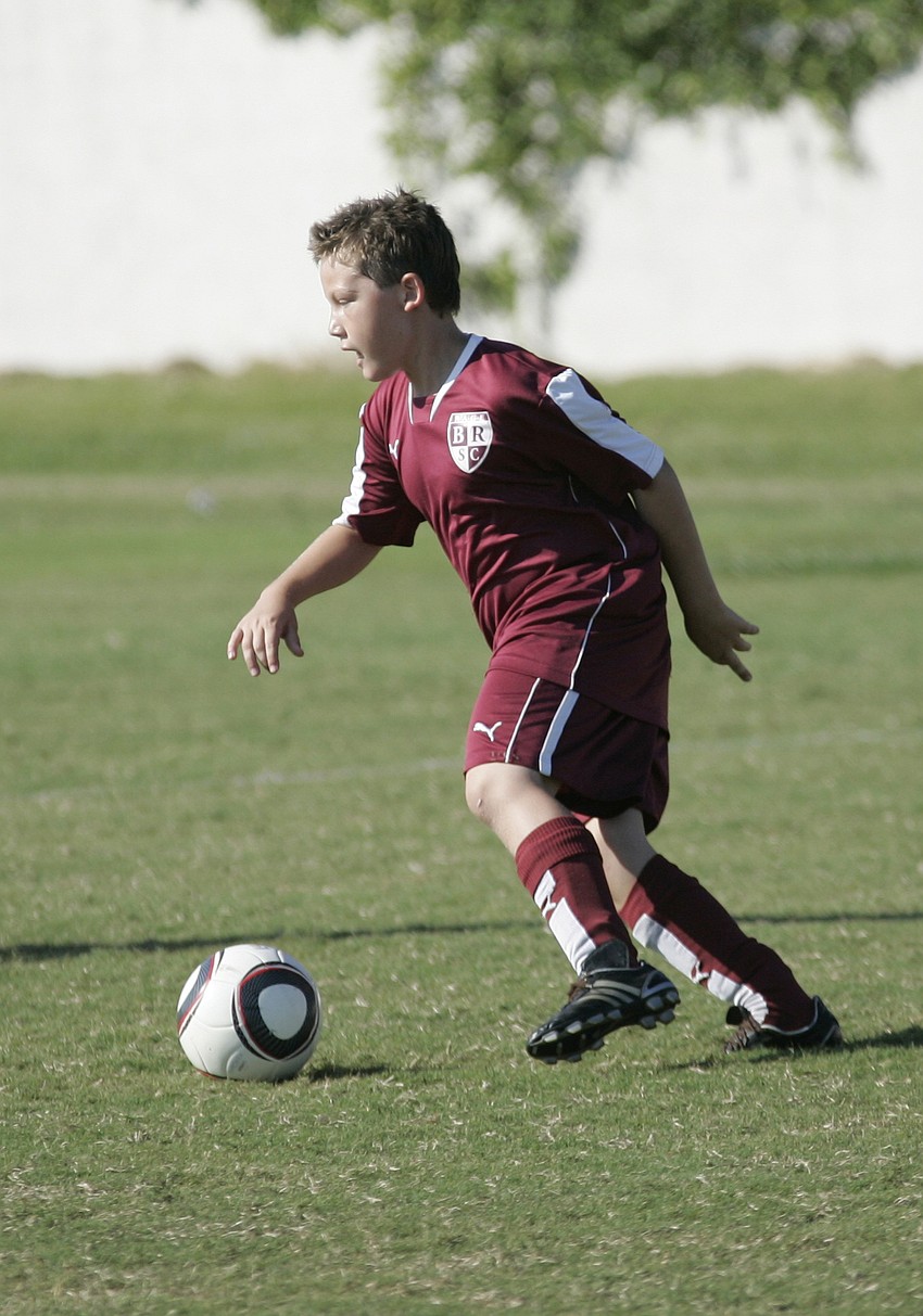 Tyler Parker, 8, dribbles the ball during his team's opening game of the tournament.