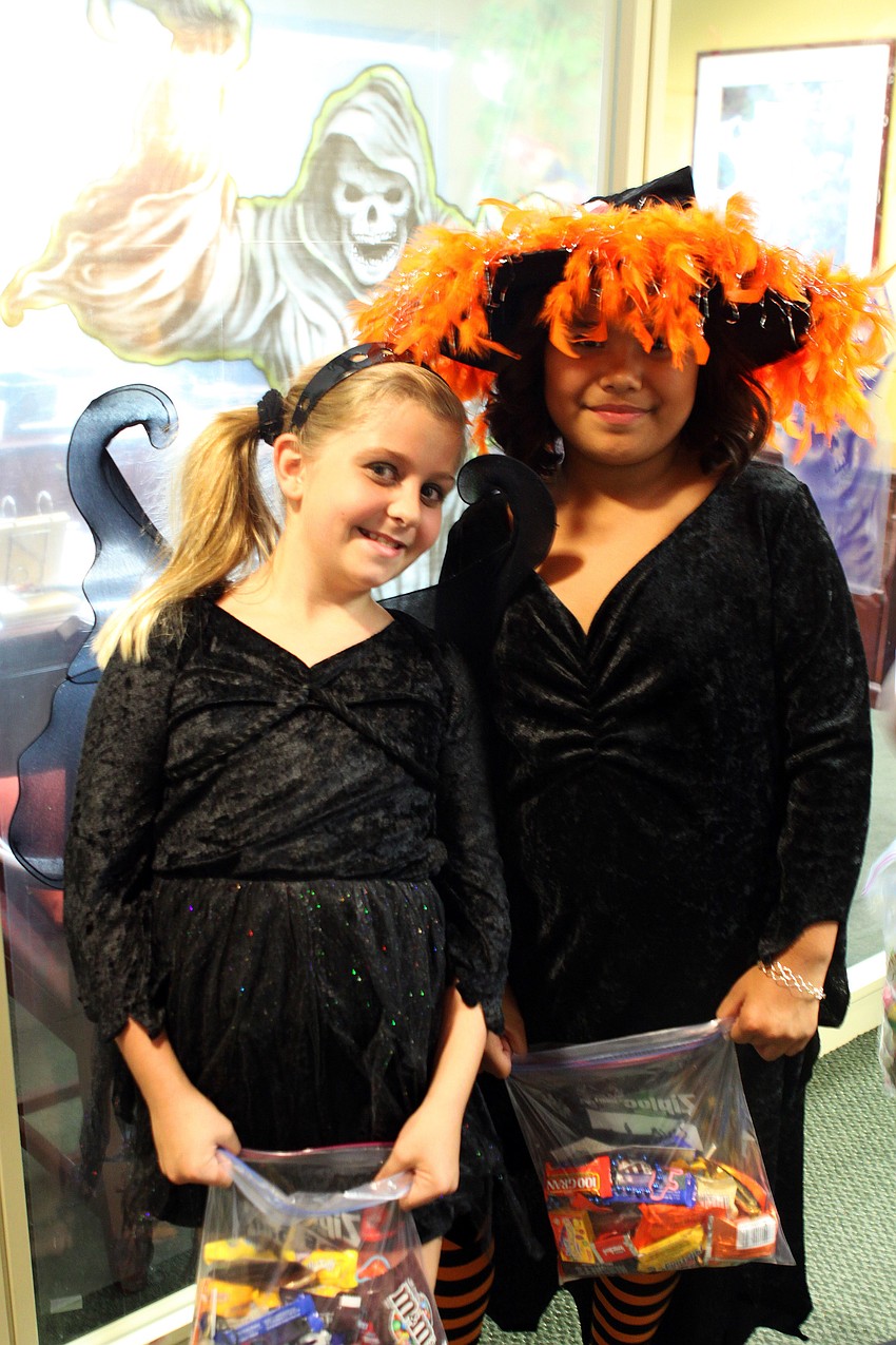 Gia Lopatinsky and Zoe Smith smile while holding their heavy bags of candy.