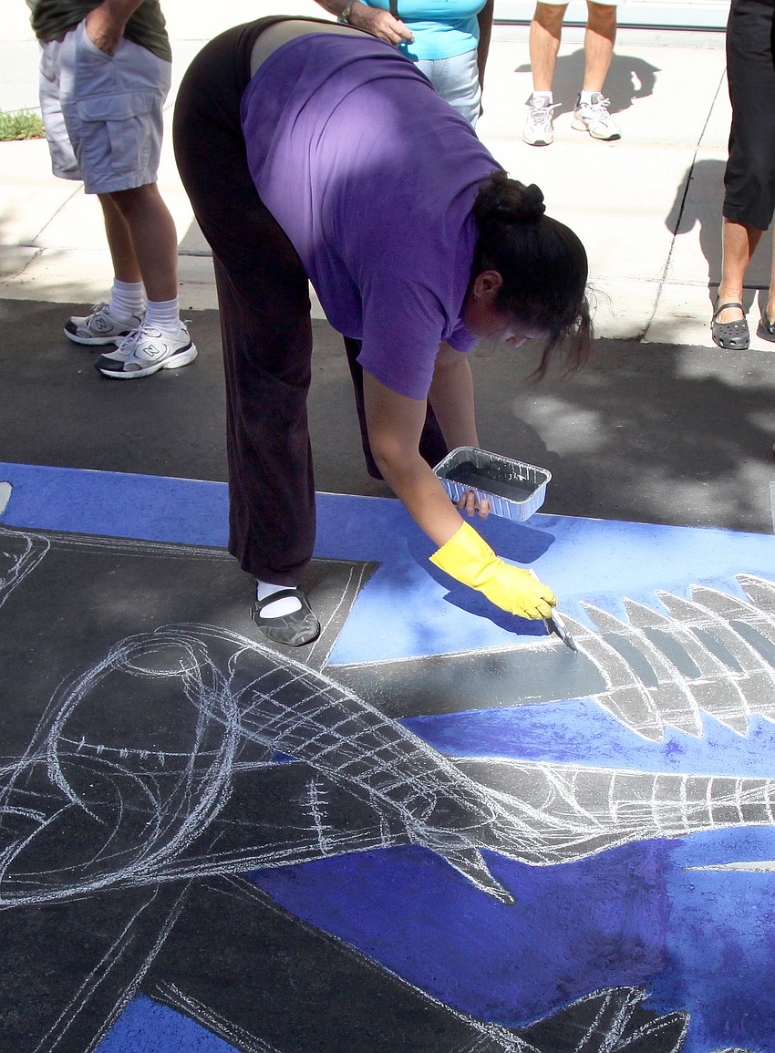 Ana Bruno uses a liquid chalk to get the base of her chalk painting done before starting in on the details.