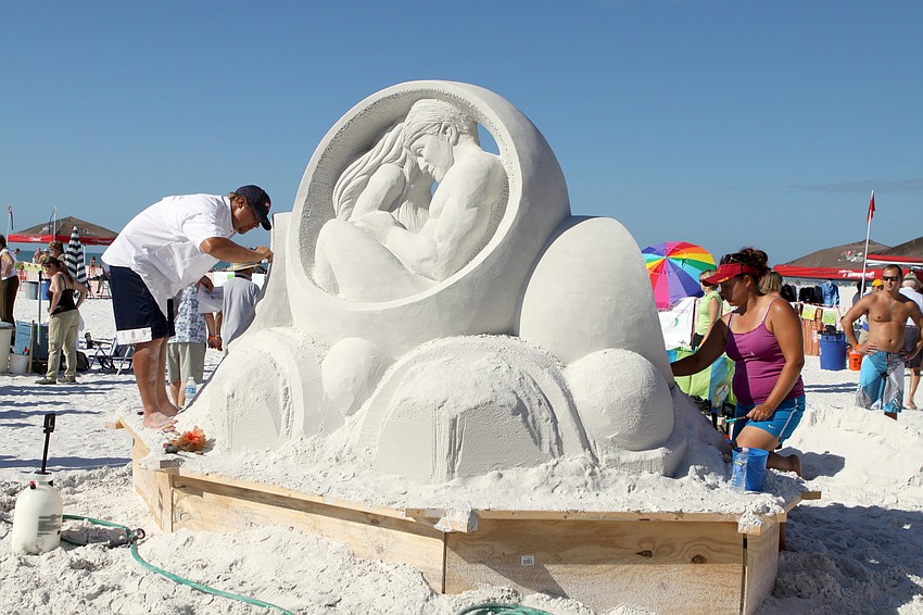 Sandis Kondrats and Sue McGrew work on their sculpture Saturday afternoon.