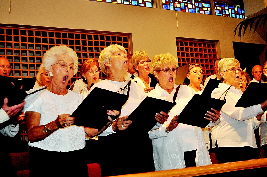 The interfaith choir joins together to lead the group in song.