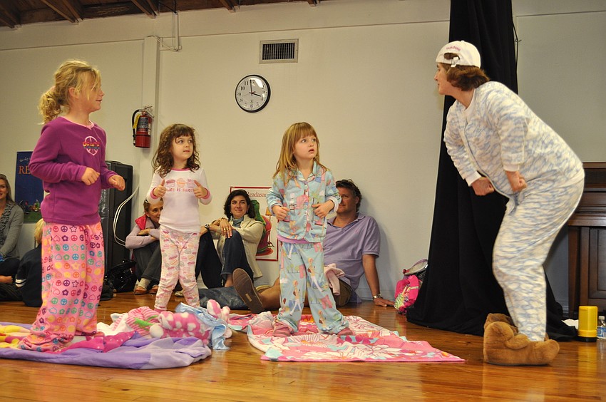 Ava Grace Krug and Chloe and Sofie Niebuhr dance with librarian Glende Huene
