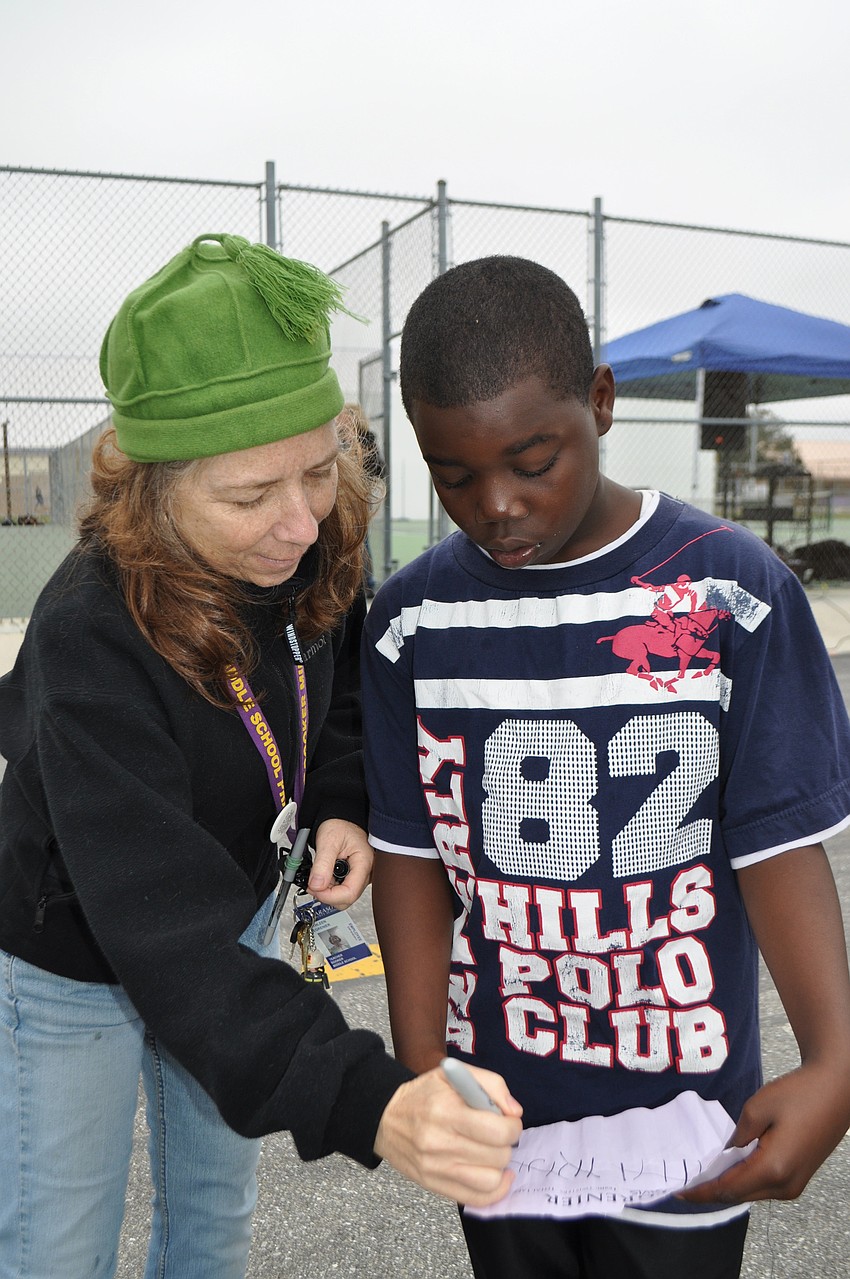 Teacher Kathy Degrenier marks off another lap completed for sixth grader Jimmy Davis.