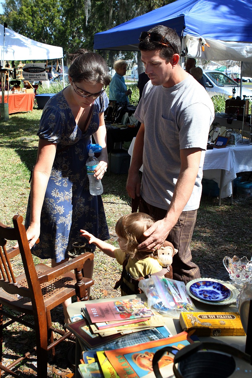 Brooks and Joe Anderson look at an antique baby chair with their son Calvin, 18 months, on Sunday, Feb. 20 at the Historical Society of Sarasota County's 2nd Annual Antiques and Appraisals Event, at Phillippi Estate.