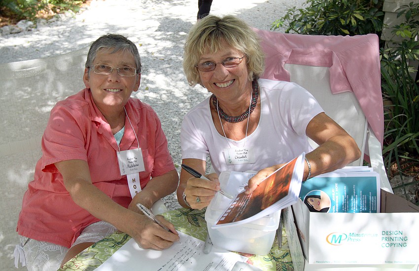 Madeleine Durand and Chantal Diem check off people's books for the Home and Garden Tour on Saturday, March 5 outside the Pressly home, one of the homes on the Home and Garden Tour.