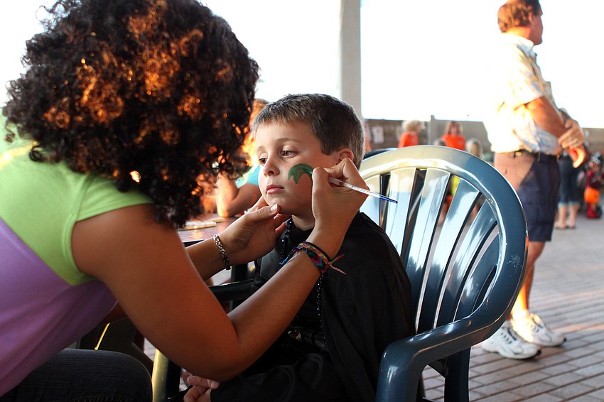 Adriana Ocana-Lara paints a moray eel on Nic Knispelâ€™s, 5, face.