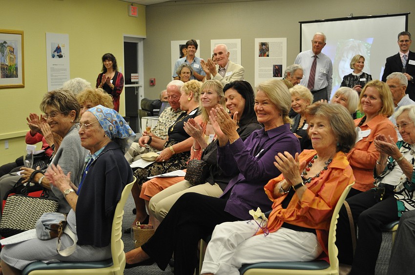 The audience of approximately 100 guests applaud the award recipients.