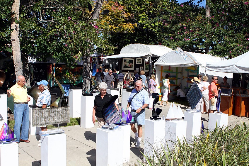 People walk around looking at pieces of art along St. Armands Circle during the 21st annual St. Armands Art Festival.