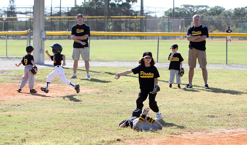 The Pirates work together in trying to throw the ball to their first baseman.