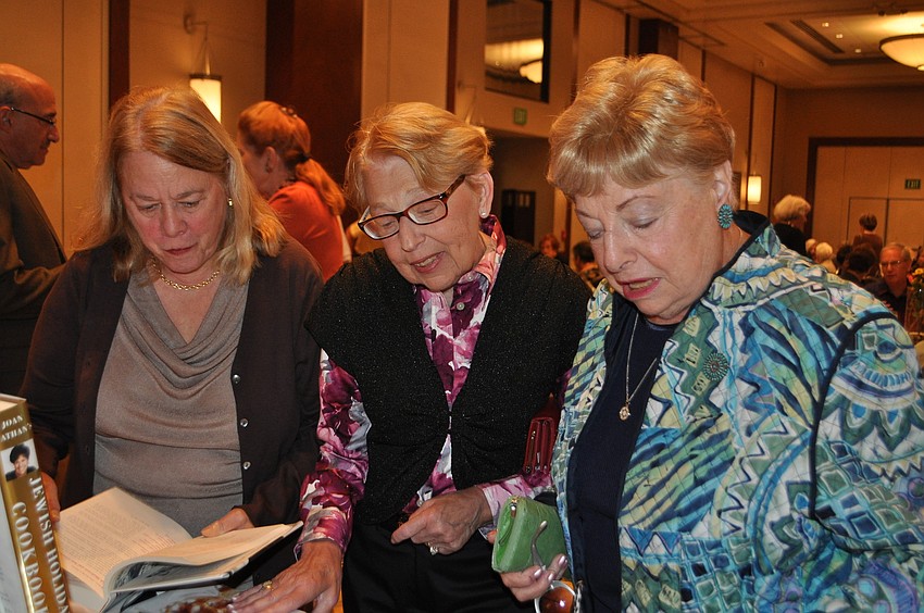 Barbara Guter, Naomi Foreman and Roslyn Shapiro browse the selection of books for sale.