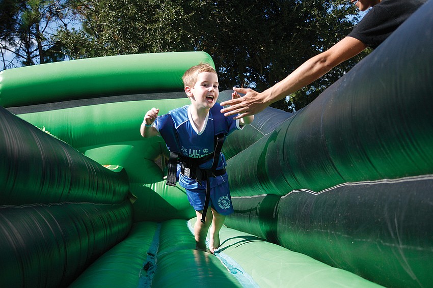Ty Dunn, 8, stretched as far as he could in the bungee rope challenge at Tara Elementar's Fall Festival. Published Nov. 25.