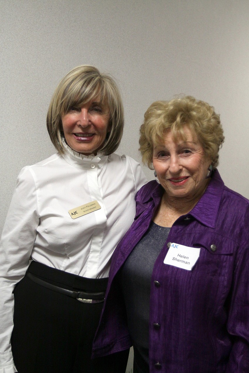 Judy Feldman and Helen Sherman pose together in the hallway in front of the new AJC office in the Bank of America Building during AJCâ€™s Grand Opening Cocktail Party Thursday evening.