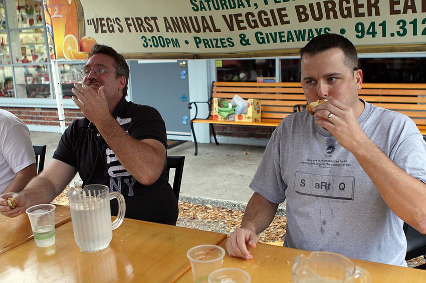Dr. Patrick Dower and Chris DeLeonardo try to beat one another during a tie-breaker round at Veg's First Annual Veggie Burger Eating Contest on Saturday, Feb. 5 outside of Veg.