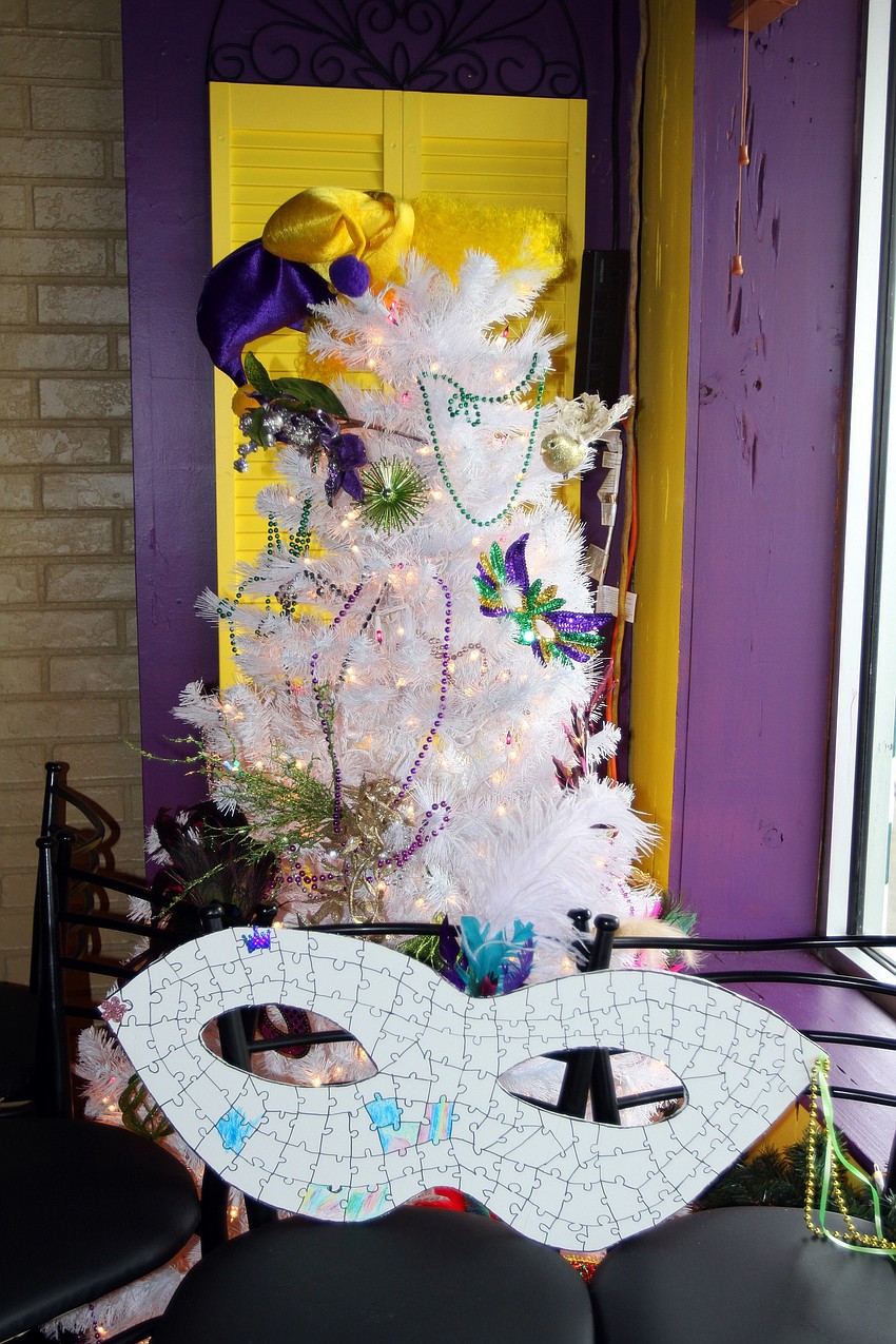 A Christmas tree decked out in Mardi Gras ornaments and a color-in oversized mask.