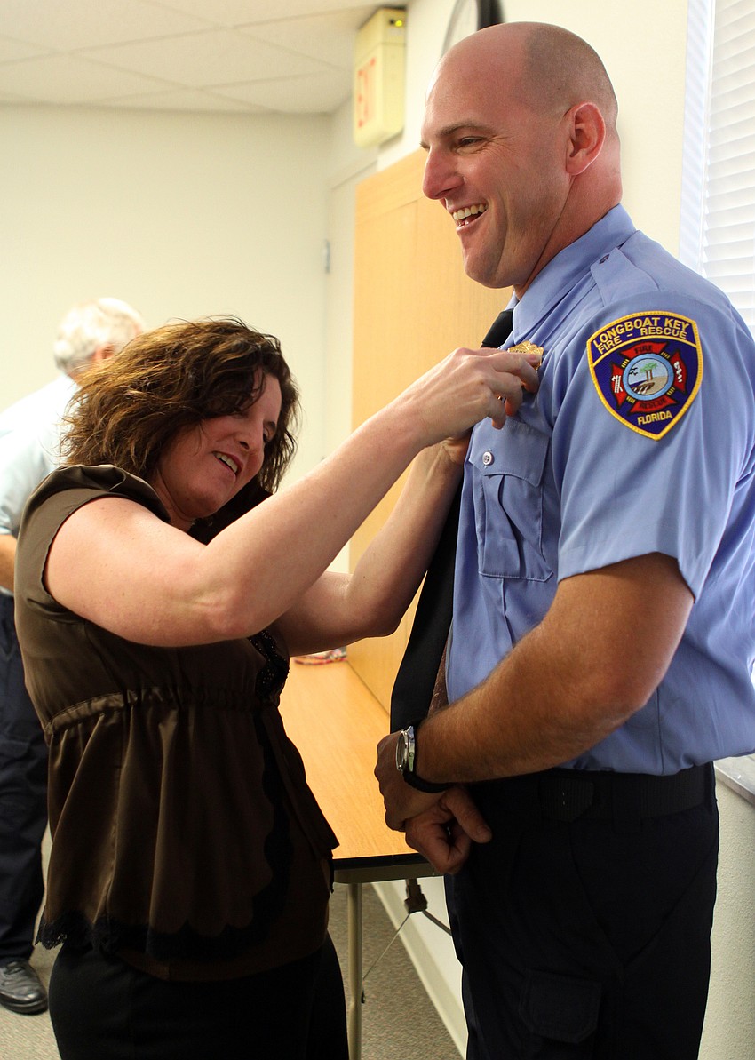 Tracy Haas has some trouble pinning on her husbandâ€™s, Tim, badge.