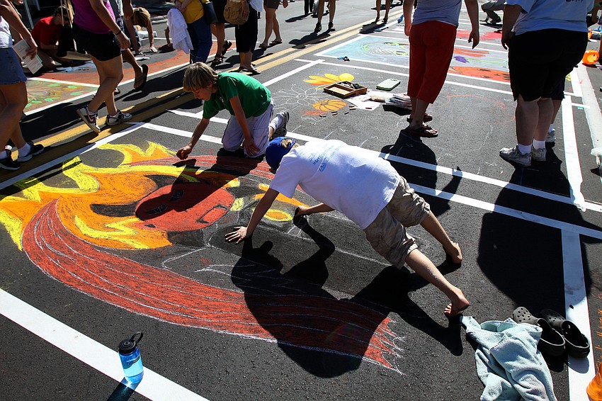 Nicholas Polokonis and Charlie Molynaux, students at Sarasota School of Arts and Sciences, work on their Halloween themed chalk drawing.
