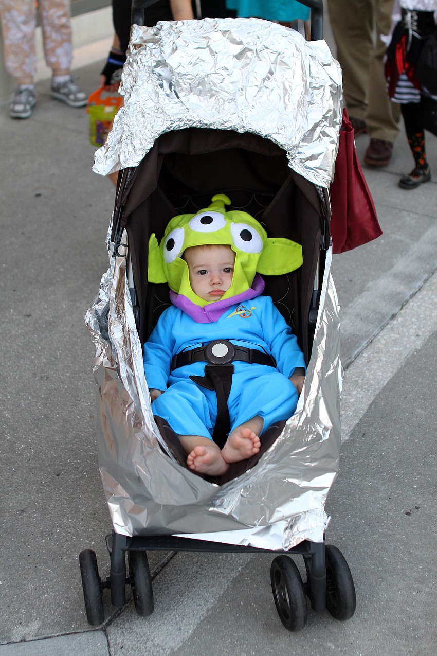 Wilfie Laurence rides in his â€œspaceshipâ€ dressed as a Green Alien from â€œToy Storyâ€.