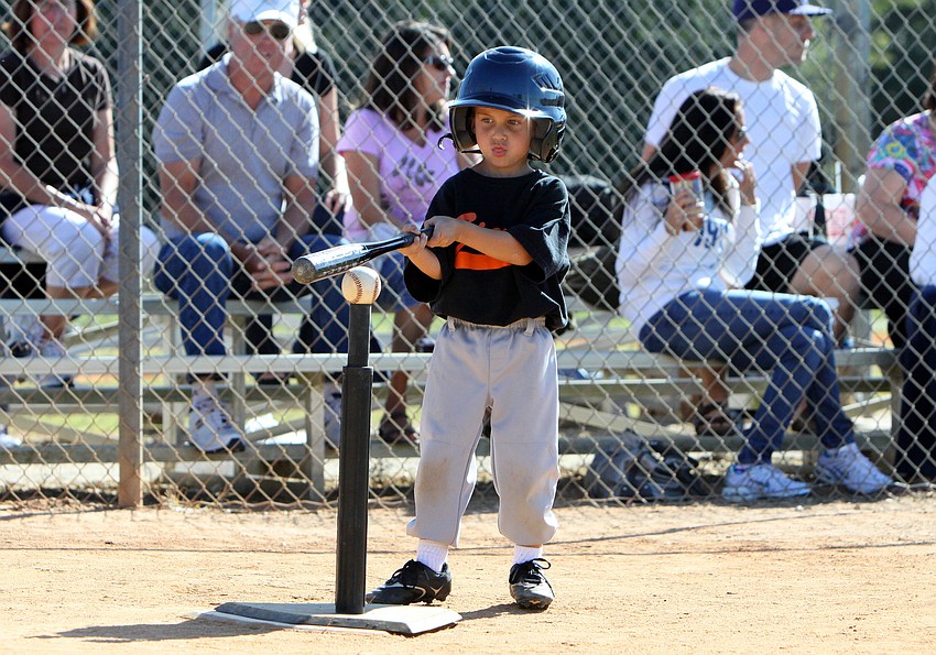 A Giants player eyes the ball prior to making his swing.
