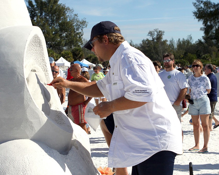 Sandis Kondrats does some detail work on his sand sculpture.