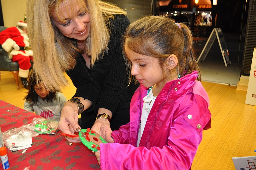 Sonia Legare does arts and crafts with Barb Wisz, left, at Comerica Bank.
