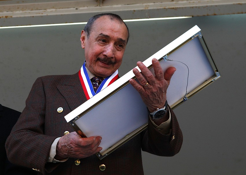 Alberto Atayde looks at the framed award that he received for being inducted into the Circus Ring of Fame.