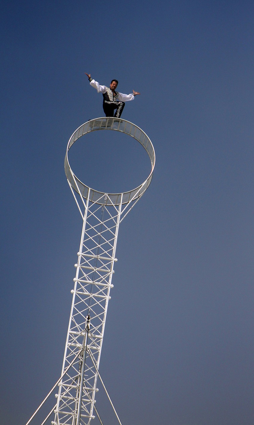 Joseph Bauer poses on the â€œWheel of Destinyâ€ while people applaud from 19-stories below.