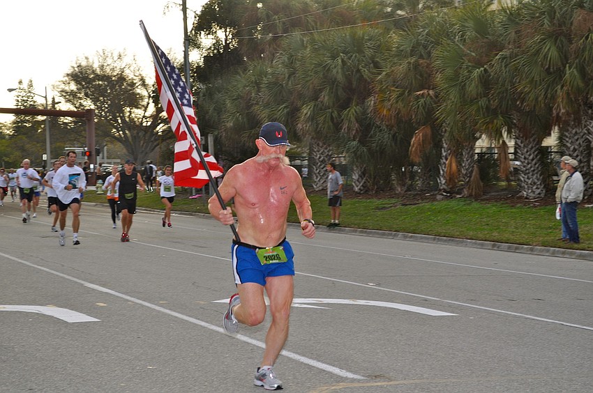 John Pyle races to the finish line carrying the American flag.