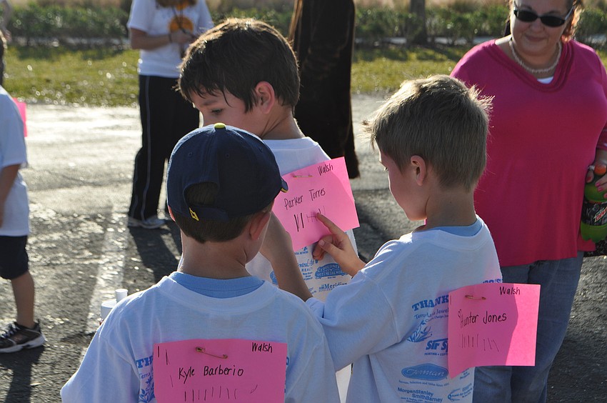 Kyle Barberio and Hunter Jones tally the laps run by classmate Parker Torres.