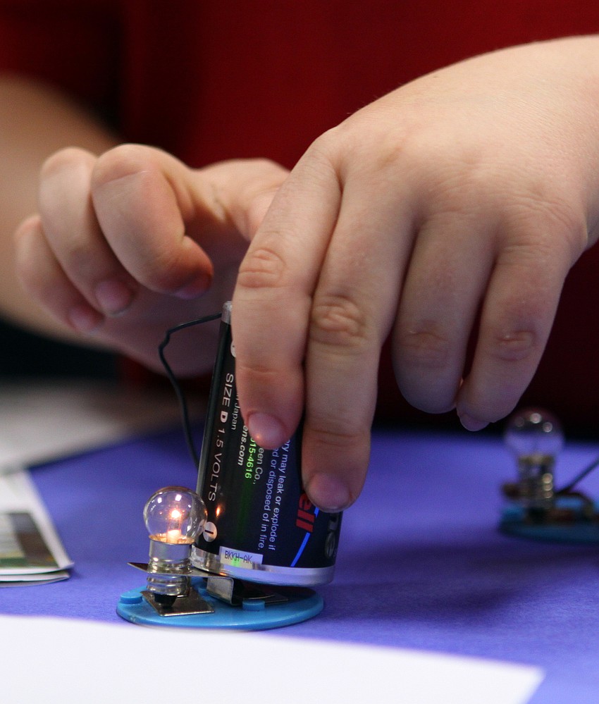Robert Stiff, second-grader, lights a tiny light bulb up by connecting a wire to a battery on Friday, Feb. 25 at Southside Elementary's Science Night.