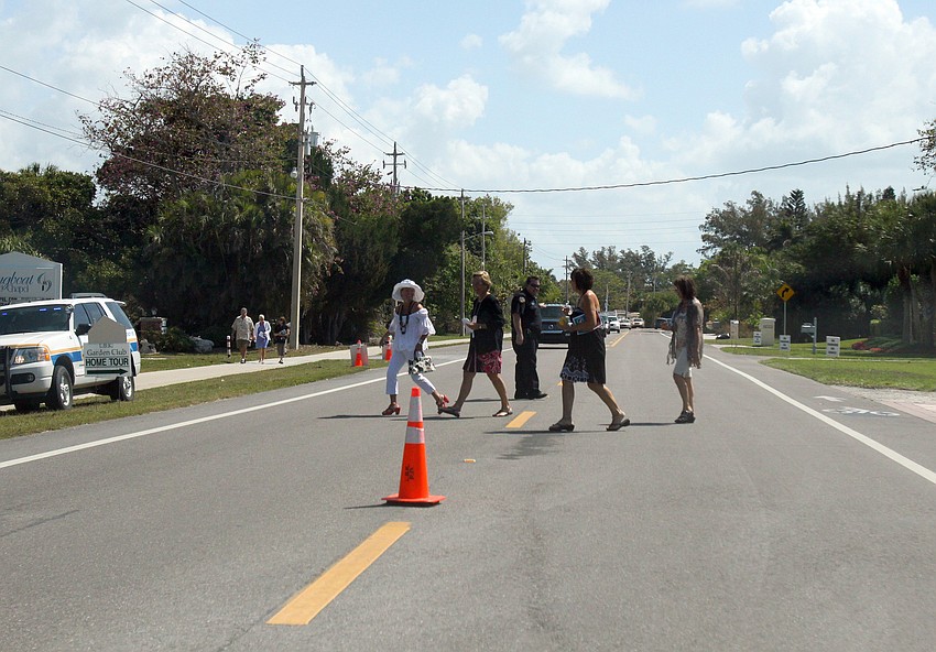 A cop stops traffic while some of the people going on the home tour cross Gulf of Mexico Drive on Saturday, March 5 during the Home and Garden Tour.