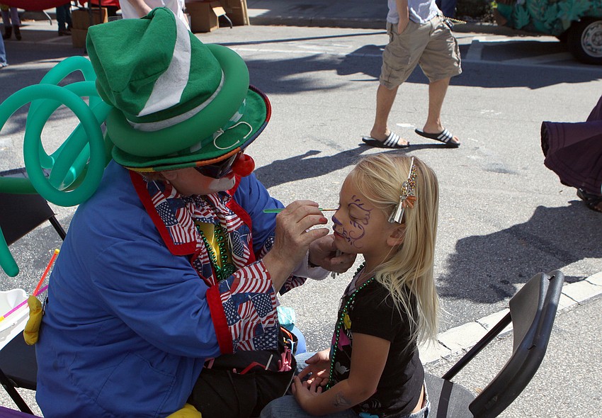 Kadynce Tallman, 4, has her face painted by Willie the Clown on Saturday, March 12 at the Sham Rock Festival on Hillview.