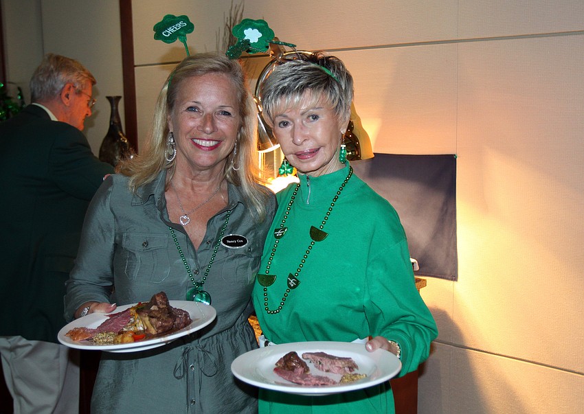 Nancy Cox and Joy Server fill their plates with Irish food at the Sarasota Yacht Club's St. Patrick's Day dinner on Thursday, March 17 in the SYC dining hall.