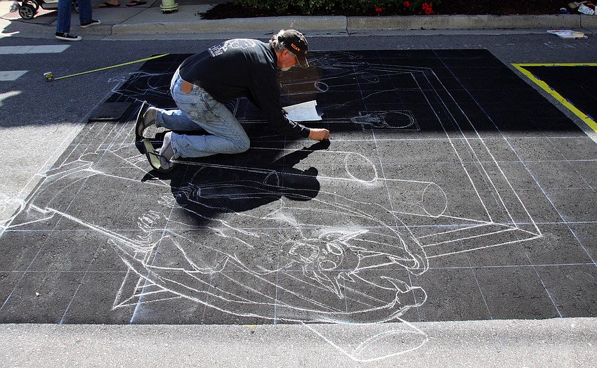 Rod Tyron, from New York, works on sketching out his picture in white chalk.