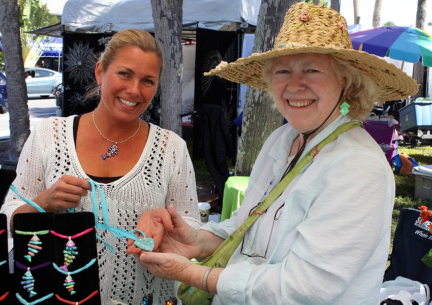 Beth Collette, owner of Beth Collette designs in glass, holds one of the two pieces of fused glass that Marietta Lee bought during the St. Armands Art Festival.
