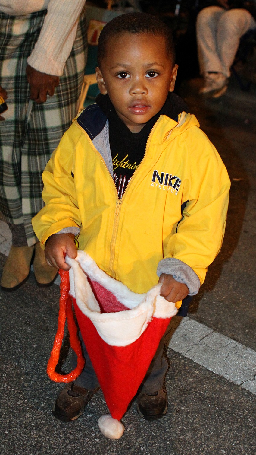 Joshua Pointdexter uses a Santa hat to collect holiday candy during the parade.