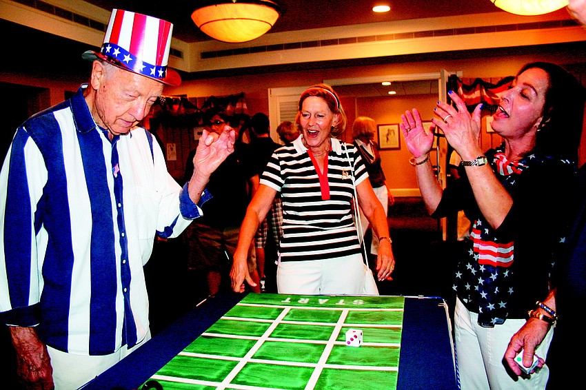Lee and Jutta Burt and Avery Dodge celebrate Lee Burt's win at the Derby game at Bird Key Yacht Club's Fourth of July party.