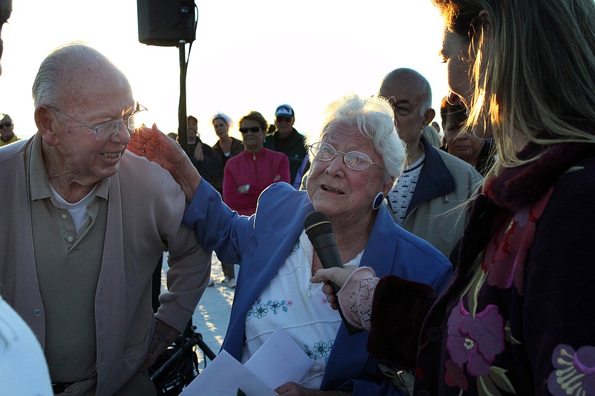 Mary Mexell tells a funny joke about her marriage to Ken into the microphone held by Jennifer Groff during the Say I Do, Again ceremony, Monday, Feb. 14 on Siesta Key Beach. The Mexell's won a gift certificate for being married the longest - 75 years.