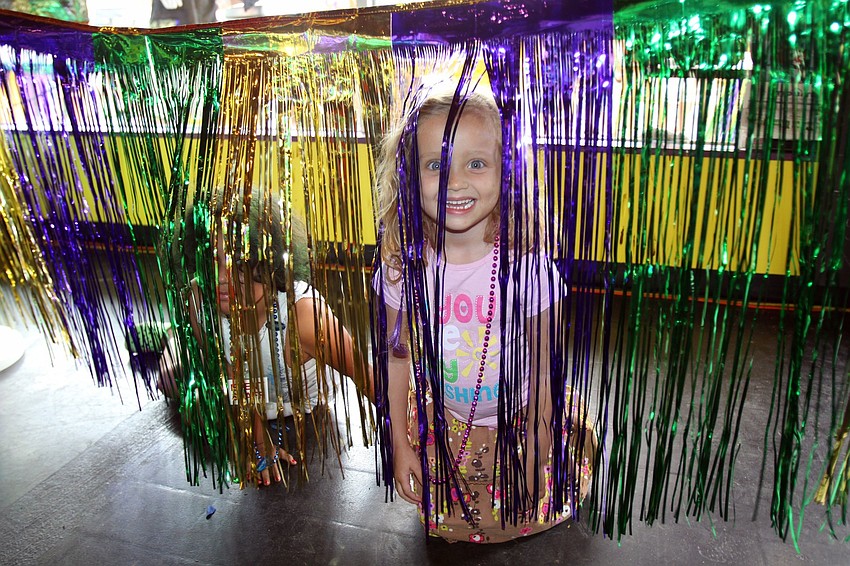 Mya Scoma and Naomi Cassagnol play with the party deocrations on Sunday, March 6 during the 1st Annual Sarasota Mardi Gras that was held at Voocaray in Gulf Gate.