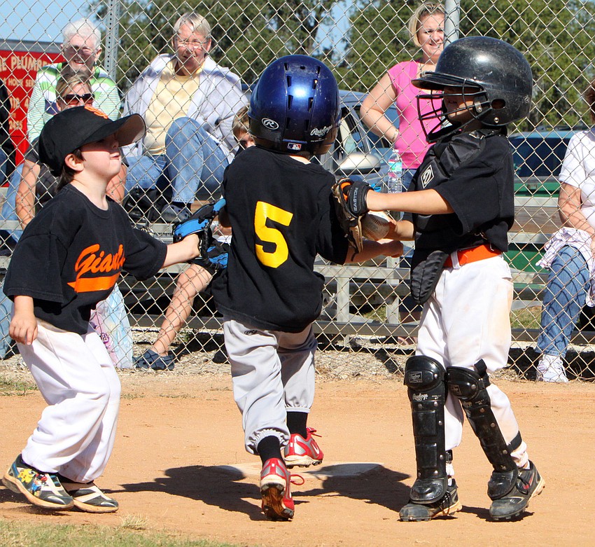 A Giants' tag-team made up of Aiden Homsey-Becker, No. 5, and Nathan Winterhalter, catcher, tag out No. 14 of the Pirates.