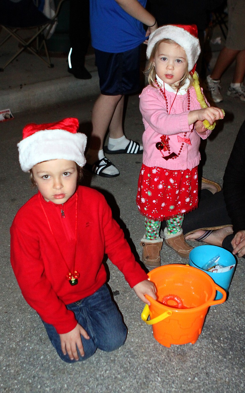 Kaleb and Mia Griffith collect tons of candy in their buckets during the parade.
