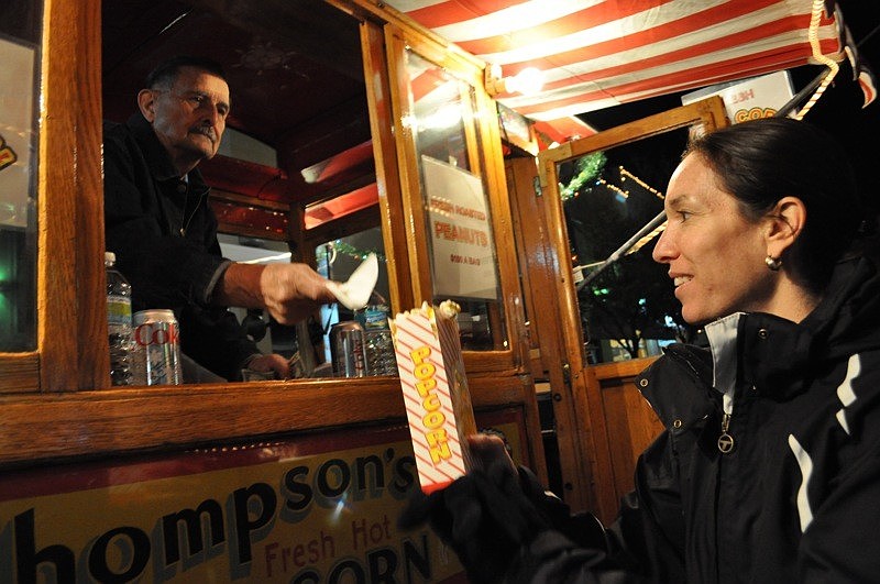 Kenneth Dunn serves popcorn to Lisa Lock from the Thompsonâ€™s Popcorn wagon.