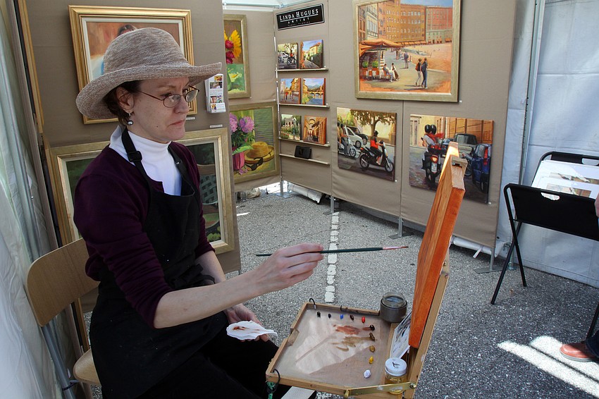 Linda Hugues paints from a picture while selling some of her paintings on Saturday, Jan. 29 at St. Armand's Art Fair.