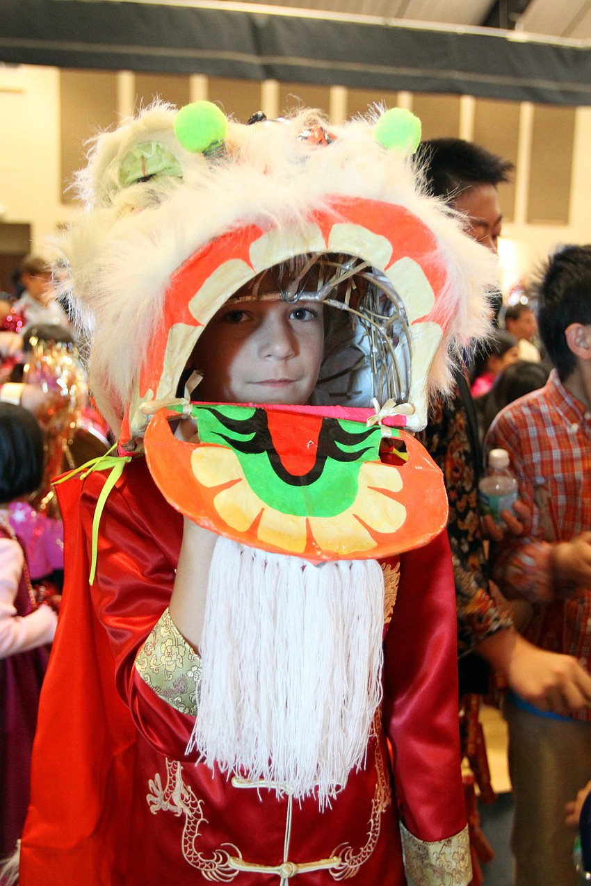Brady Truedinger, 9, from the Sarasota Chinese Academy, puts on his lion head prior to going on stage on Saturday, Jan. 29 at the 2011 GCAA Chinese New Year Celebration held at T.J. Johnson Youth Center.